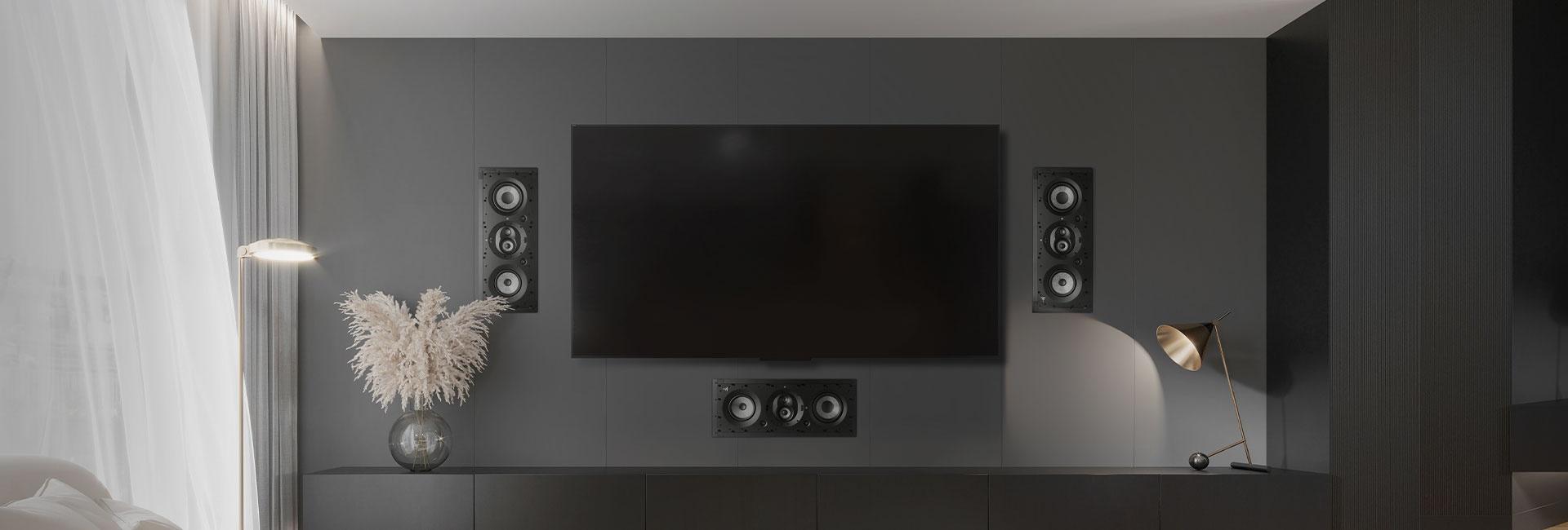 Modern dark-toned media room with in-wall speakers surrounding a flat TV