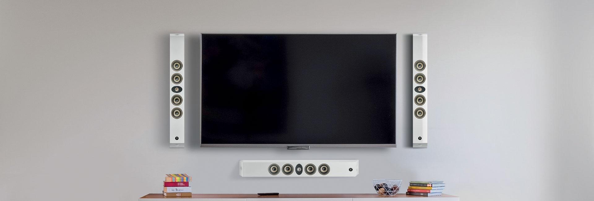 Clean media setup with white in-wall speaker system and flat TV on gray wall