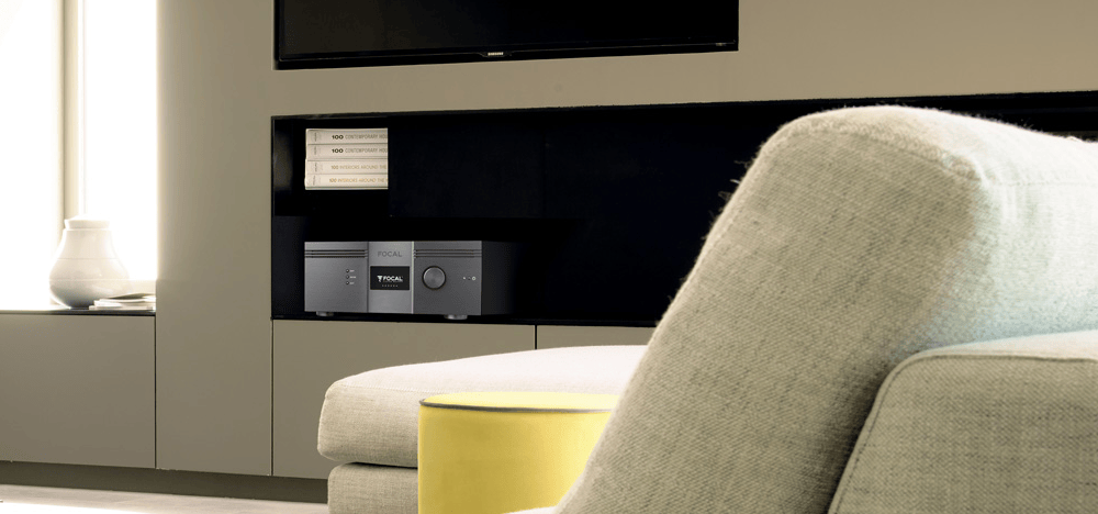 Sleek audio amplifier in built-in shelving below TV in contemporary living room