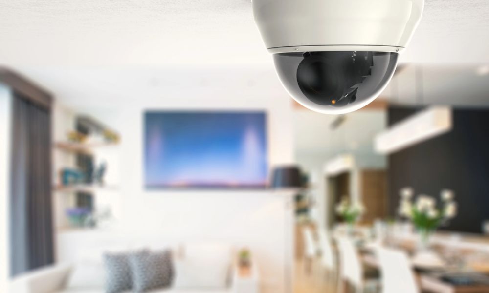 <span class="uk-h4">Ceiling-mounted dome security camera in a modern living and dining area, providing discreet home surveillance.</span>