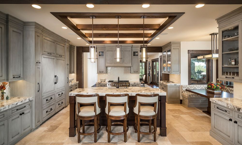 <span class="uk-h4">DMF Lighting in-ceiling and pendant fixtures in a large kitchen area with gray cabinets.</span>