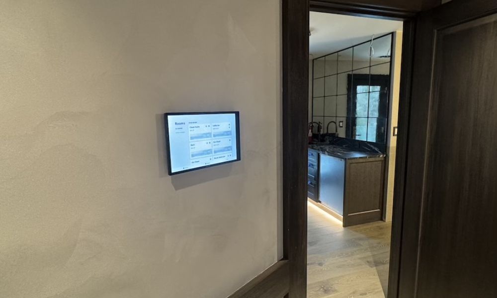 <span class="uk-h4">A Crestron control panel mounted on the wall outside of a breakroom.</span>