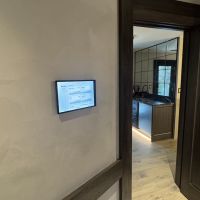 A Crestron control panel mounted on the wall outside of a breakroom.